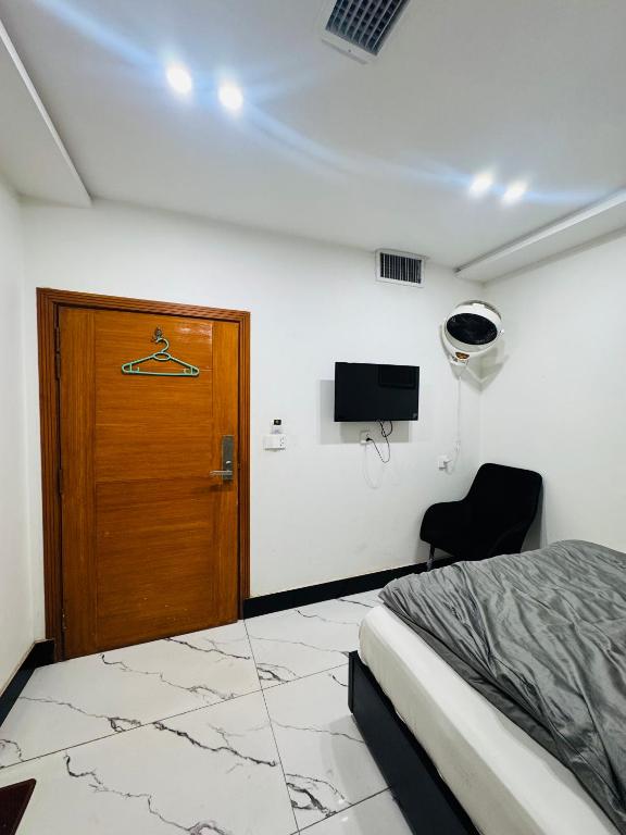 a bedroom with a bed and a door and a chair at Mc Lodge 