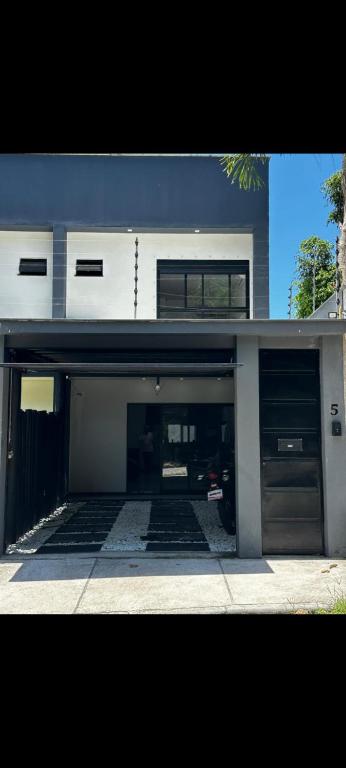a building with two garage doors and a driveway at Apartamento aconchegante e moderno próximo do aeroporto e ao centro in Porto Seguro