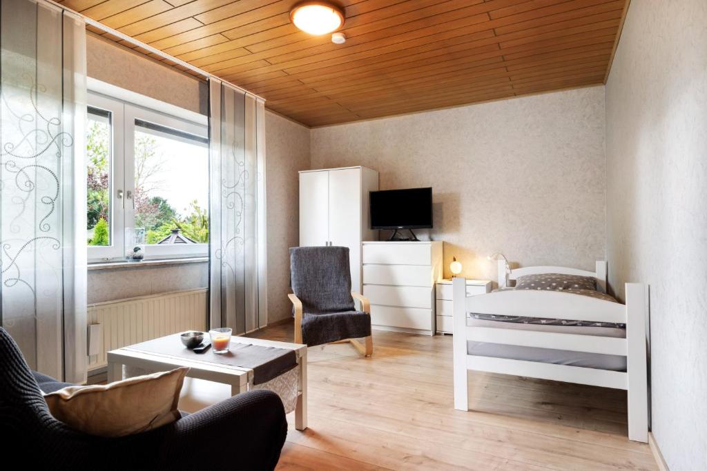 a bedroom with a bed and a chair and a table at Monteurwohnung in Schwanewede