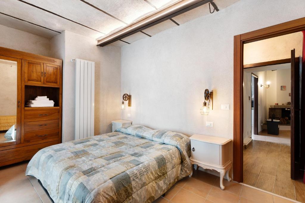 Un dormitorio con una cama grande y un espejo. en Casa Vacanze Laghi e Monti, en Mergozzo