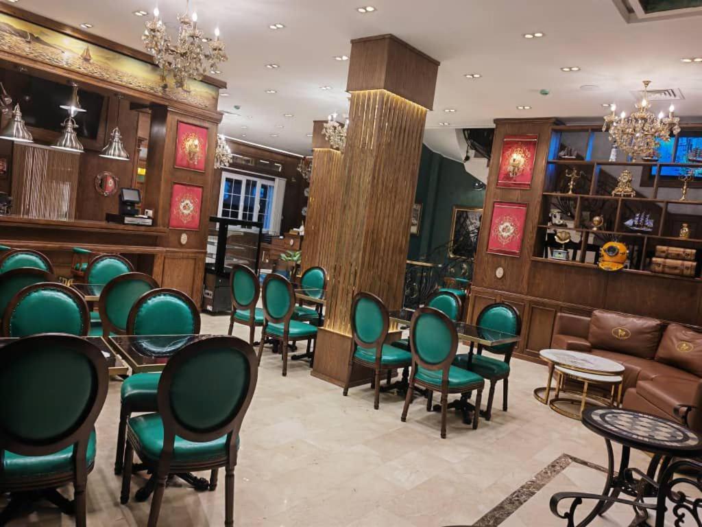 a restaurant with green chairs and tables in a room at Amirale in Oran
