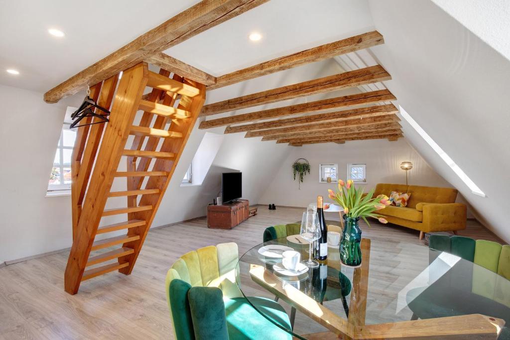 a living room with a table and a spiral staircase at Alte Post in Münsingen