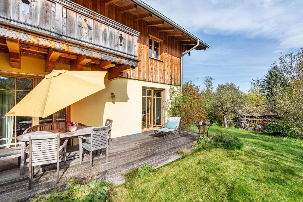 a wooden deck with a table and chairs on a house at Tegernseele in Gmund am Tegernsee