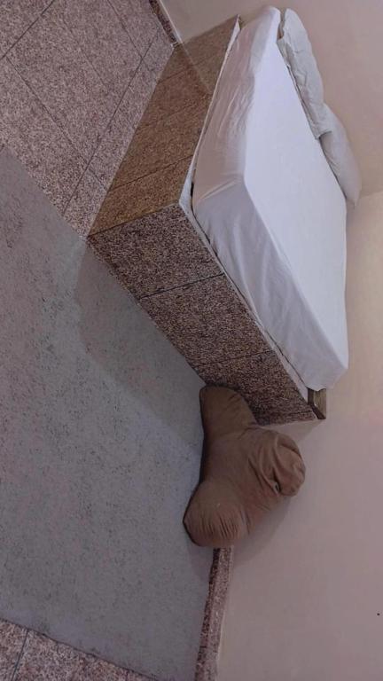 a white bag on the floor next to a shoe at Quarto de temporada in Belém