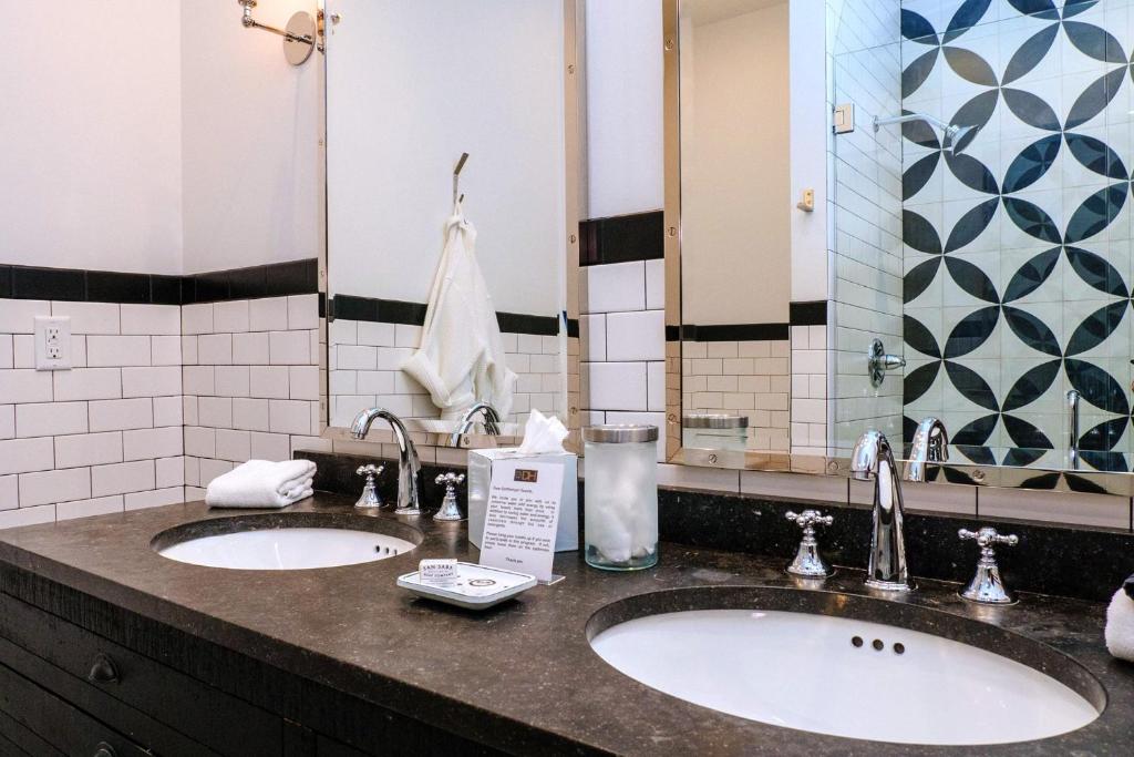 a bathroom with two sinks and two mirrors at Dofflemyer Hotel in San Saba