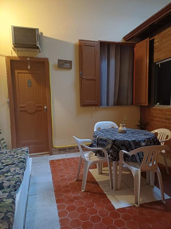 a dining room with a table and chairs and a tv at Quarto Suite na Gavea in Rio de Janeiro