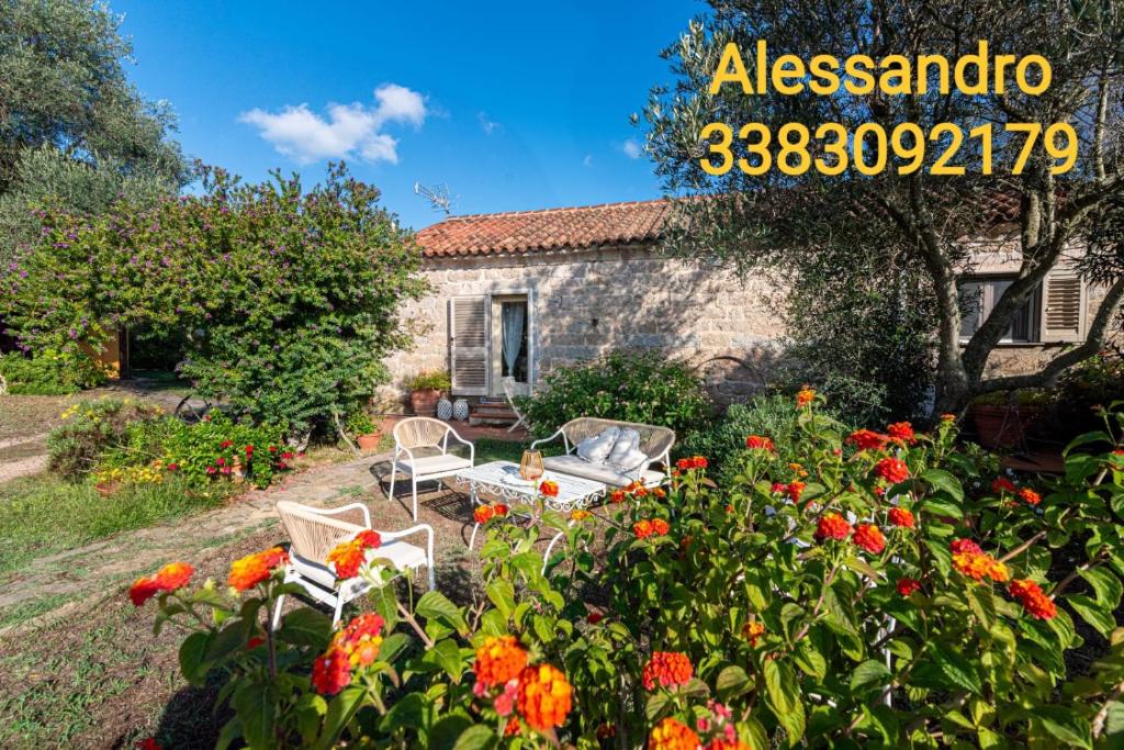 a stone house with a garden with flowers at Casa Lilliosa in San Pasquale