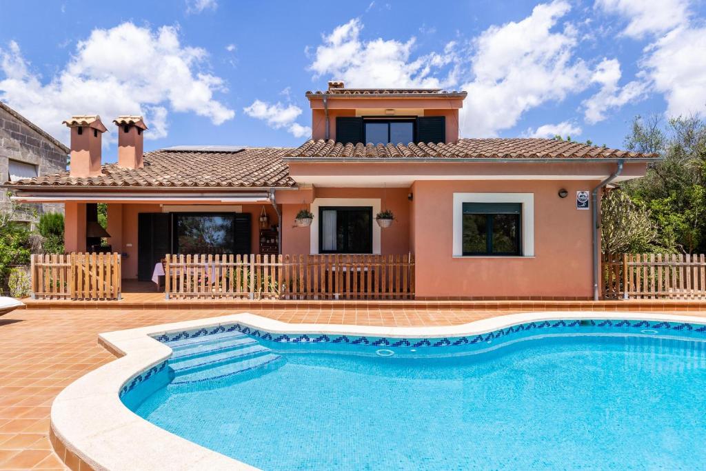a villa with a swimming pool in front of a house at Ses Buguenvílies in Marratxí 