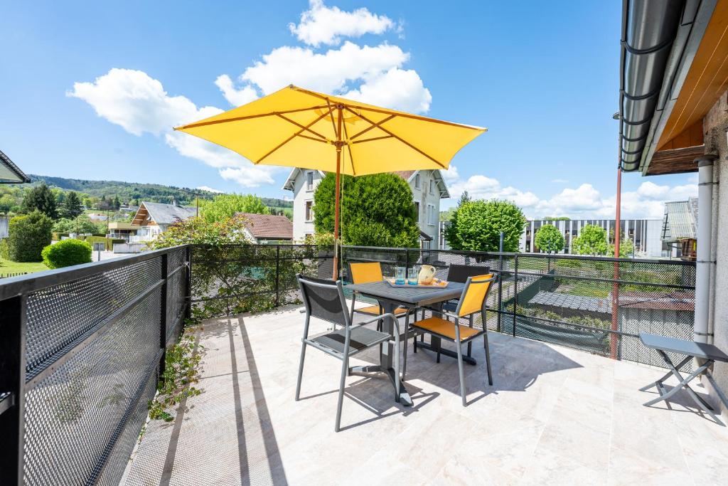 eine Terrasse mit Tisch, Stühlen und Sonnenschirm in der Unterkunft La Maison Marie Andre in Albens