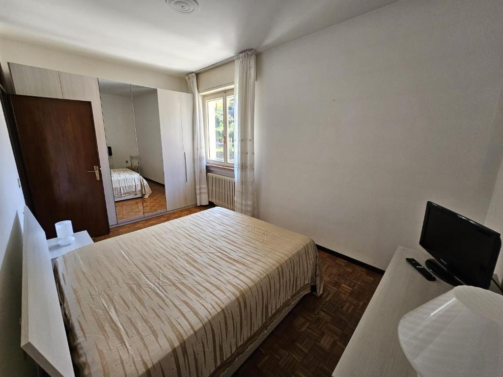 a small bedroom with a bed and a television at Riverside San Pellegrino in San Pellegrino Terme