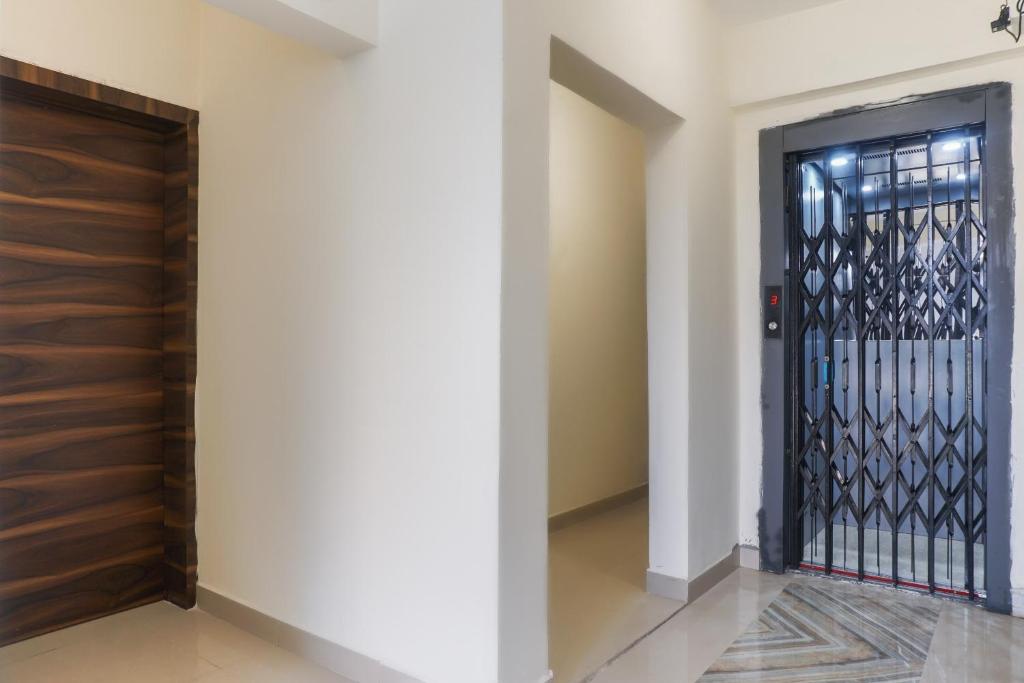 a hallway with a black door and a wall at Collection O Palm Bliss in Kharadi