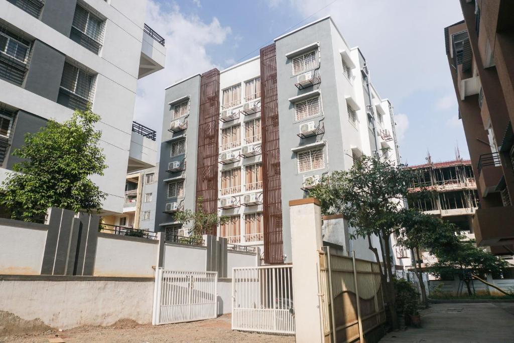 un edificio de apartamentos con una valla delante en Collection O Palm Bliss, en Kharadi