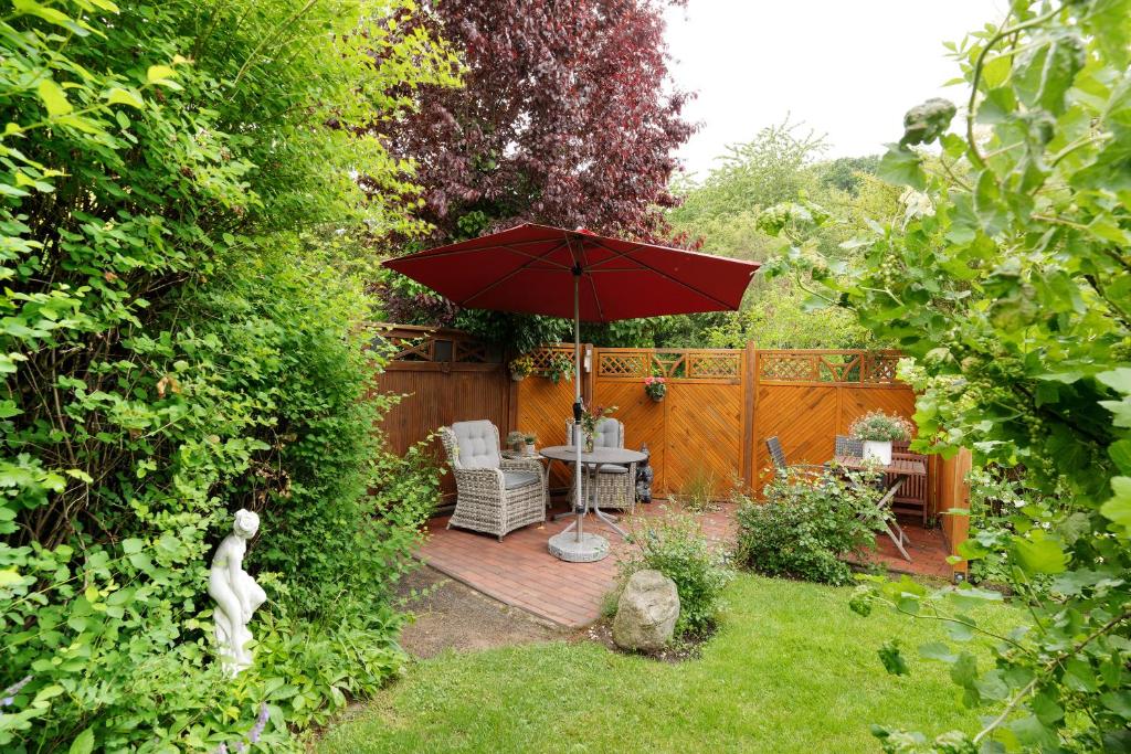 un patio avec une table, des chaises et un parasol dans l'établissement Ferienwohnung Haus Fahrenkrog, à Wittmoldt