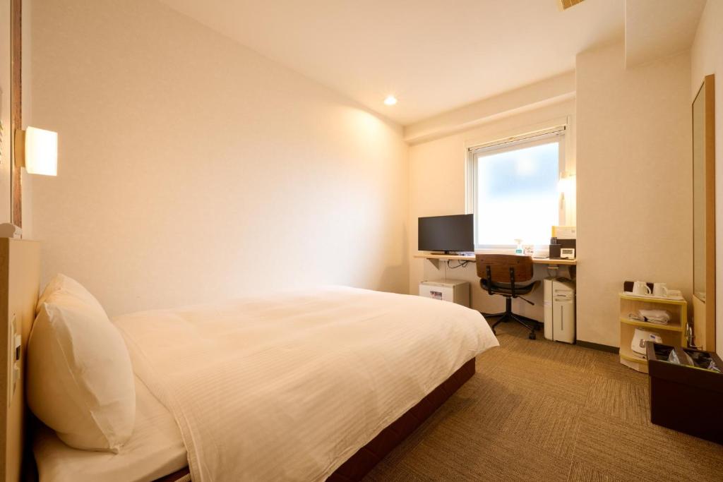 a bedroom with a bed and a desk and a window at Smile Hotel Kyoto Karasuma Gojo - Vacation STAY 69565v in Kyoto