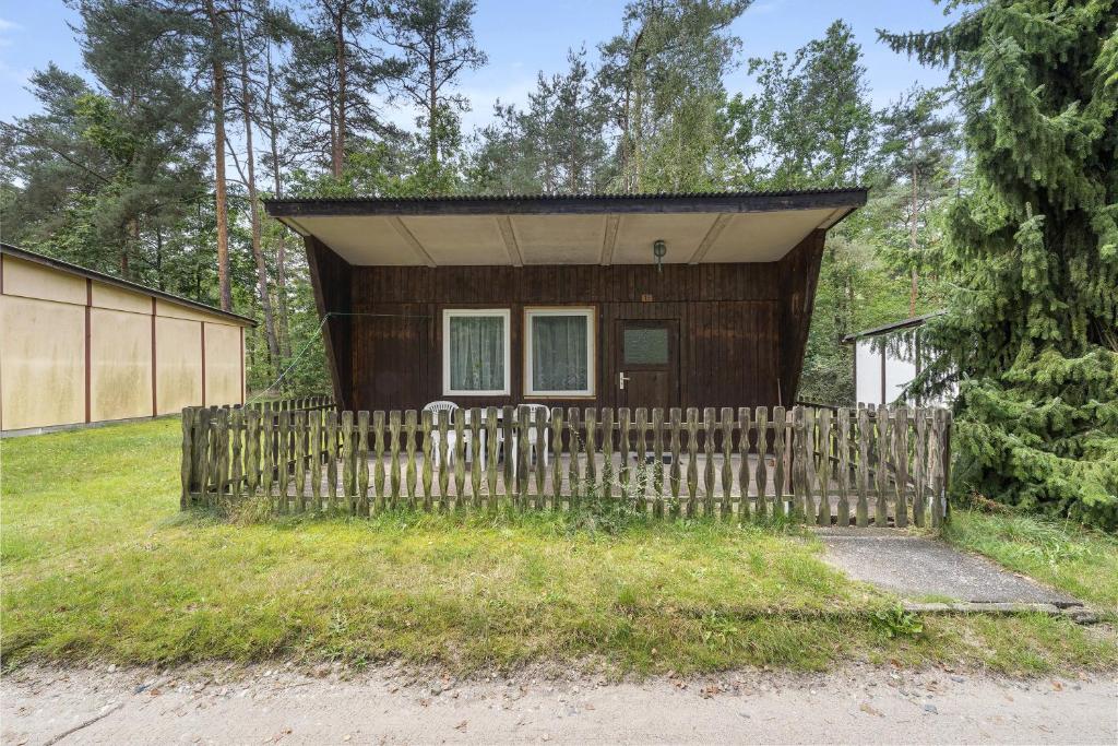 une petite maison avec une clôture devant dans l'établissement Bungalow 19 - Kimbucht, à Reichendorf