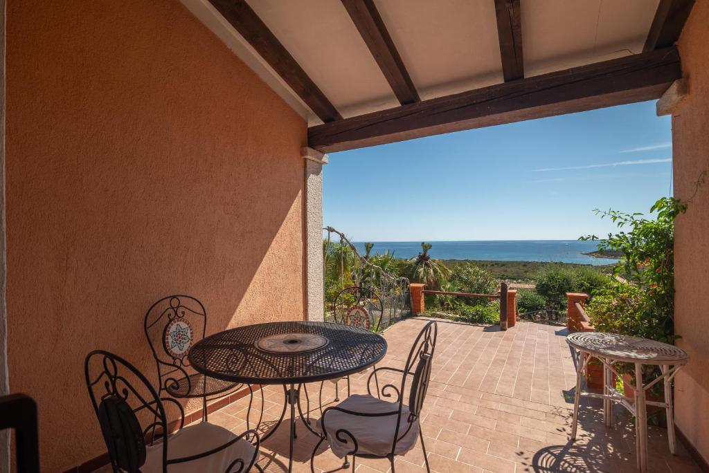 a patio with a table and chairs and a view of the ocean at Villa Anna in San Teodoro