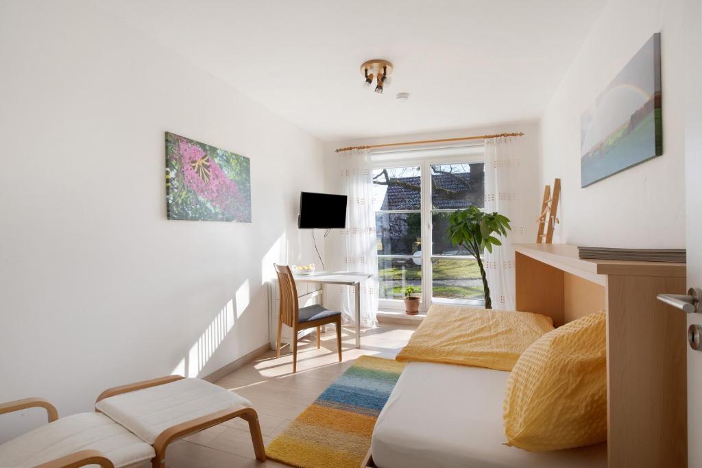 a living room with a couch and a desk at Birkethof Gartenblick in Grimoldsried