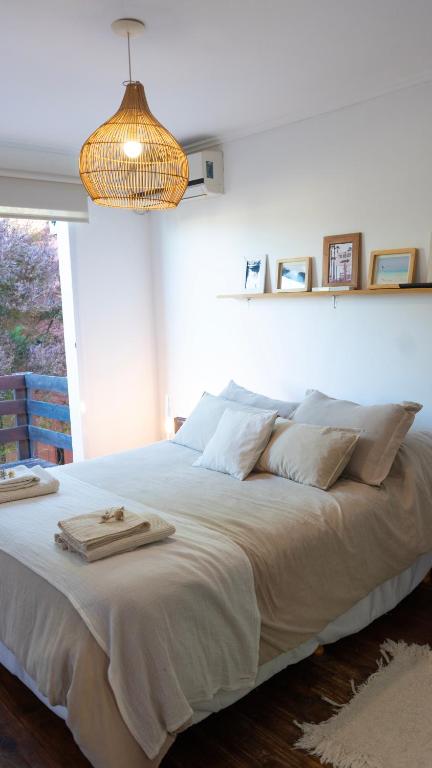 a bedroom with a large white bed with a chandelier at Verde Lillo in Necochea