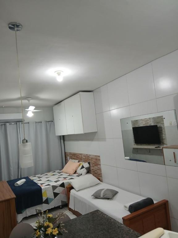 a small room with two beds and a tv at Aconchegante Apto de 1qt a 60mts do Consulado EUA in Recife