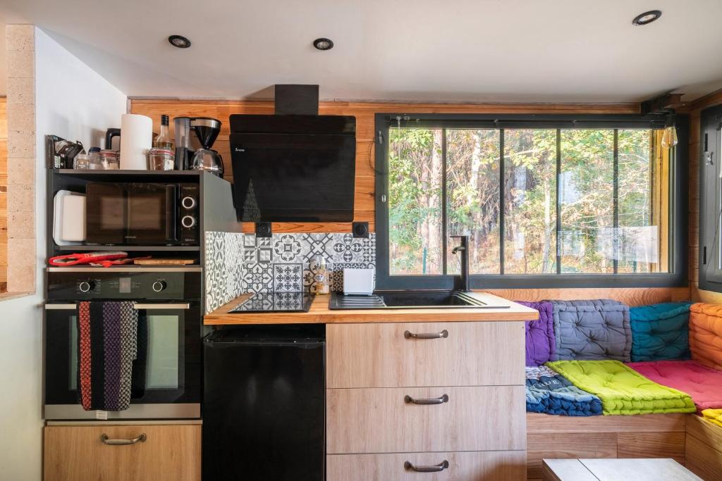 d'une cuisine équipée d'un réfrigérateur noir et d'une fenêtre. dans l'établissement Lou Cabanot 640 portes du Bassin, à Le Barp