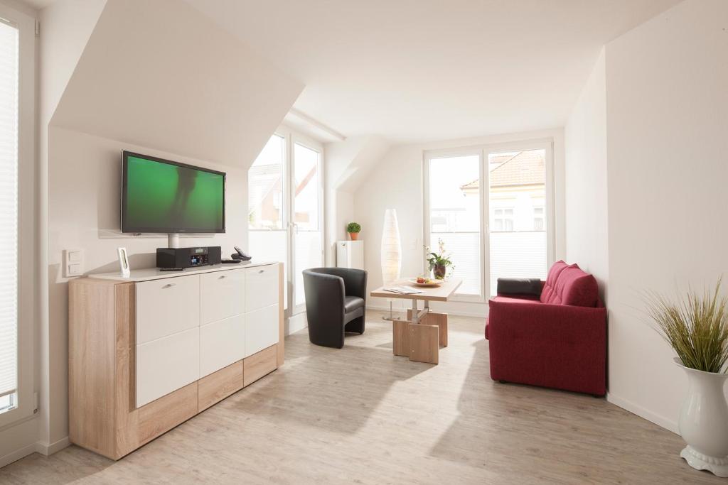a living room with a tv and a red couch at Komfort Wohnung Benekestraße 5 Nr 7 in Norderney
