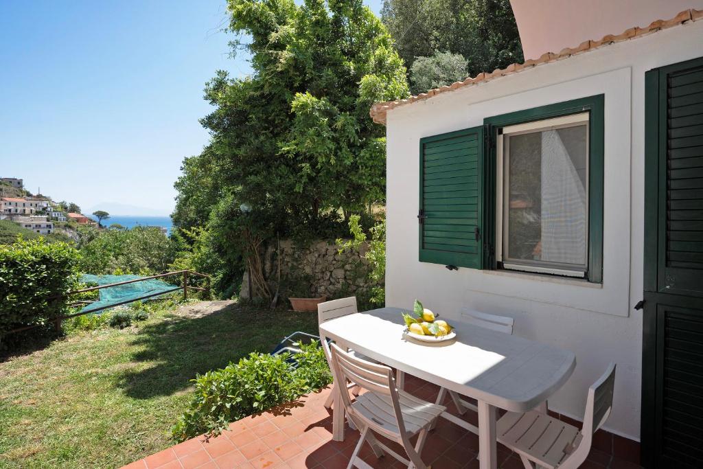 エルキエにあるCasa Vacanze Mare E Limoniの窓のあるパティオ(テーブル、椅子付)