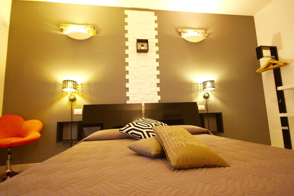 a bedroom with a bed with two lights on the wall at Park 20 Guesthouse in Olbia