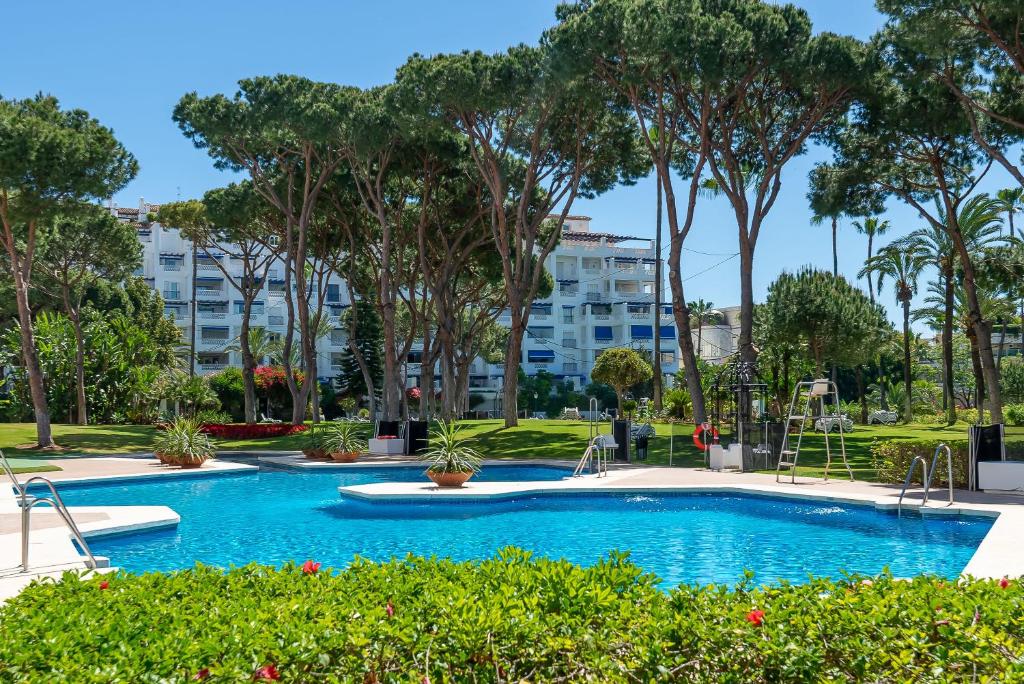 una piscina en un parque con árboles en Beachside Puerto Banus Luxury Aprt3, en Marbella