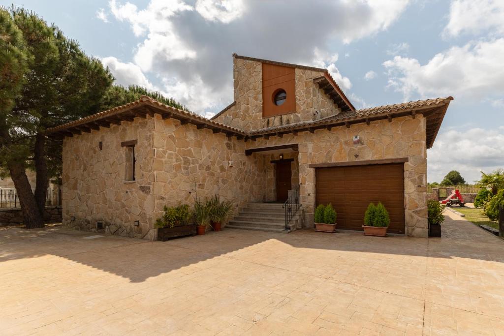 a large stone building with a large garage at Sierra Norte Madrid in El Berrueco
