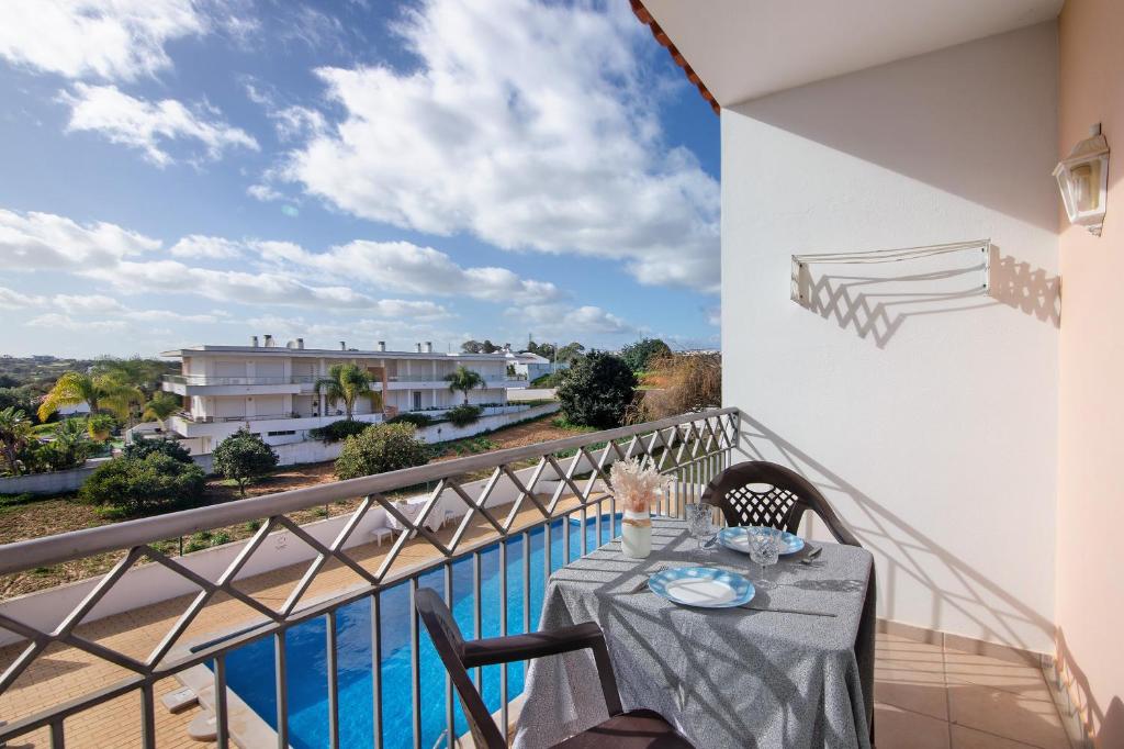 a table on a balcony with a view of the water at T1 Apartamentos Vista Alegre in Albufeira