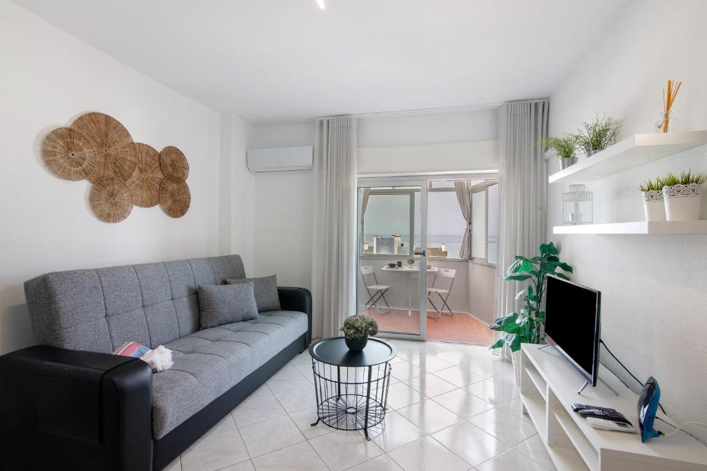 a living room with a couch and a table at T1 com vista mar in Quarteira