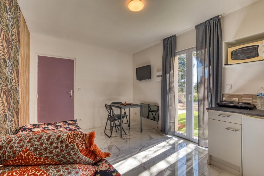 un soggiorno con letto e tavolo con sedie di Studio Poussan a Poussan