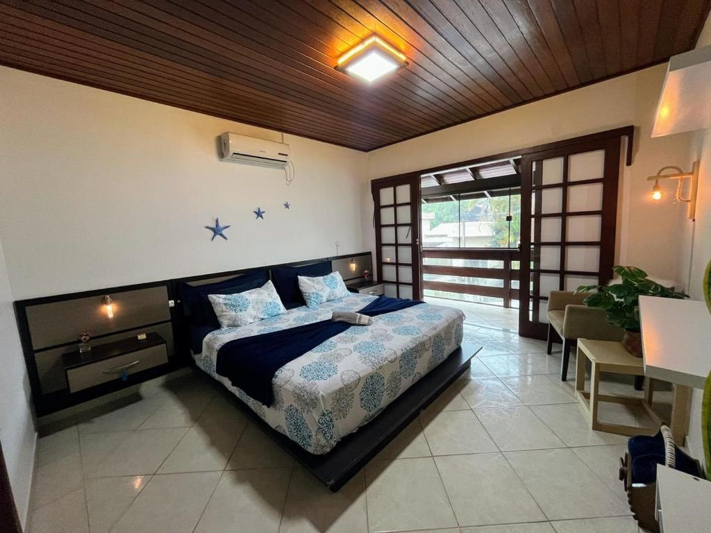 Pousada com café da manhã, piscina, natureza, sossego no Norte da Ilha, Ingleses في فلوريانوبوليس: غرفة نوم بها سرير وتلفزيون