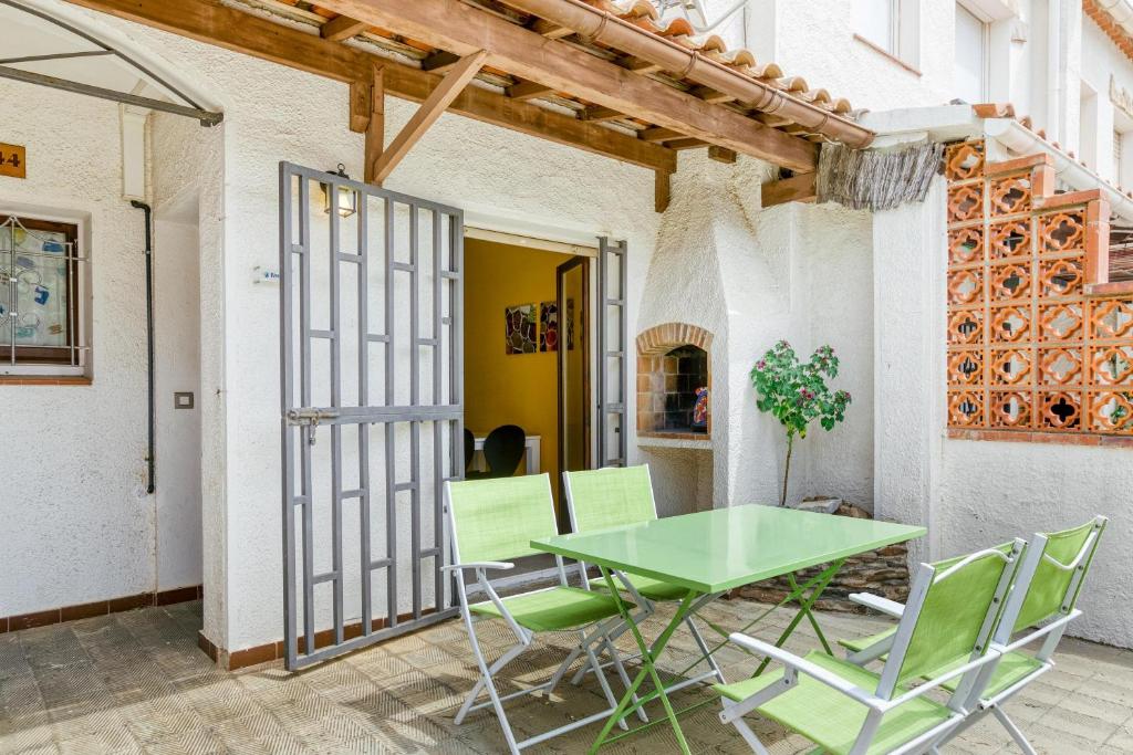 une table et des chaises vertes sur la terrasse dans l'établissement Apartamento Roses Victor, à Roses