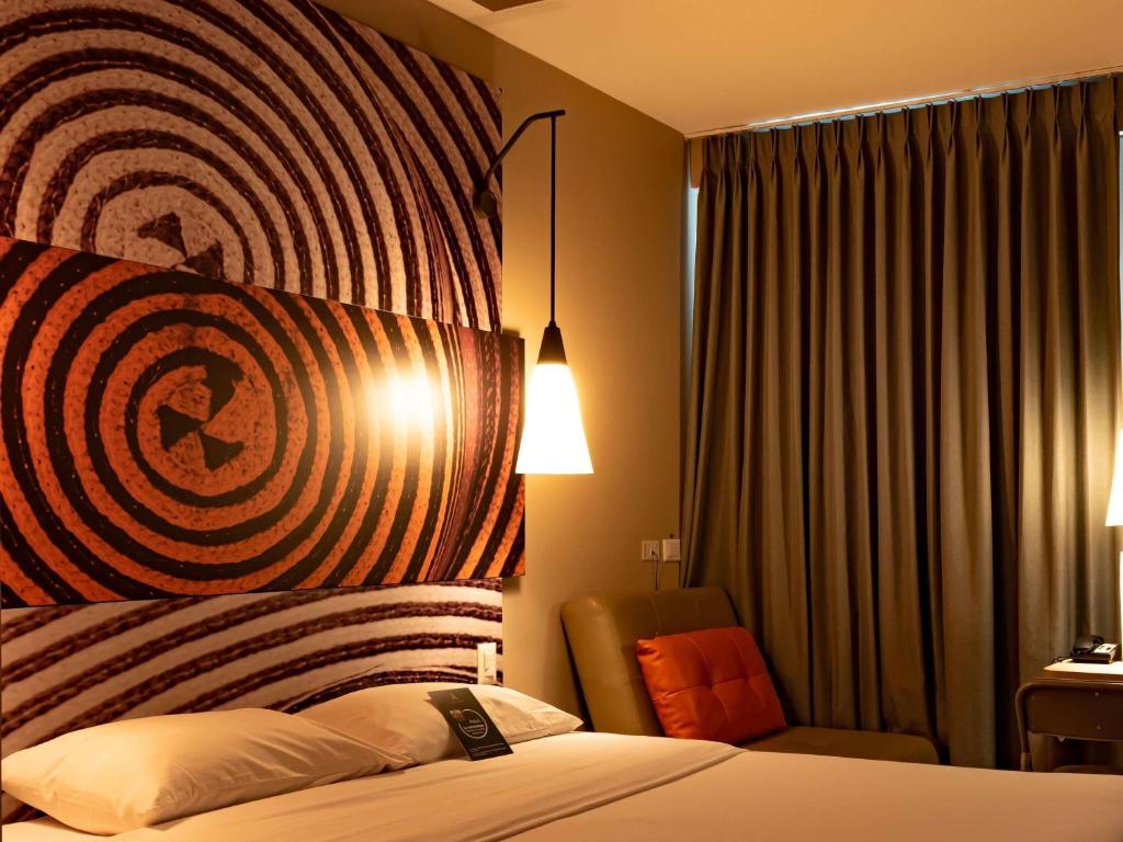 a hotel room with a bed and a chair at ibis Apartado in Apartadó