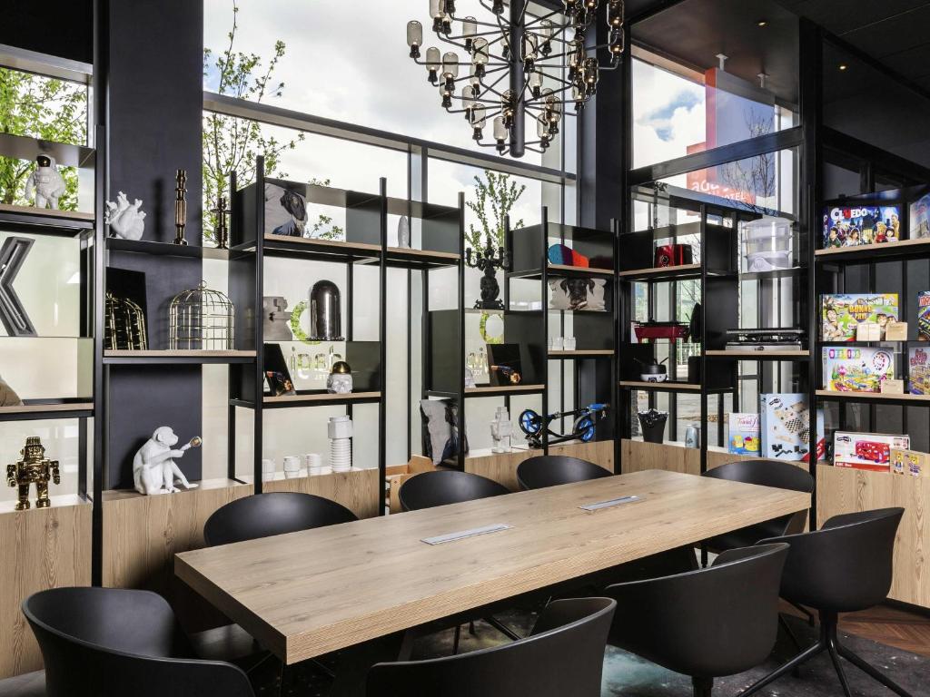 a dining room with a wooden table and chairs at Aparthotel Adagio access Palaiseau Saclay in Palaiseau