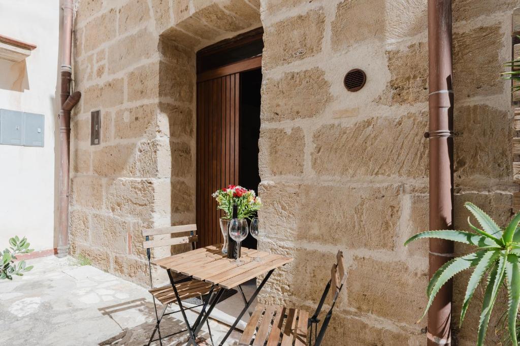 a table and chairs on a patio with a window at Casa Velella in Castellammare del Golfo