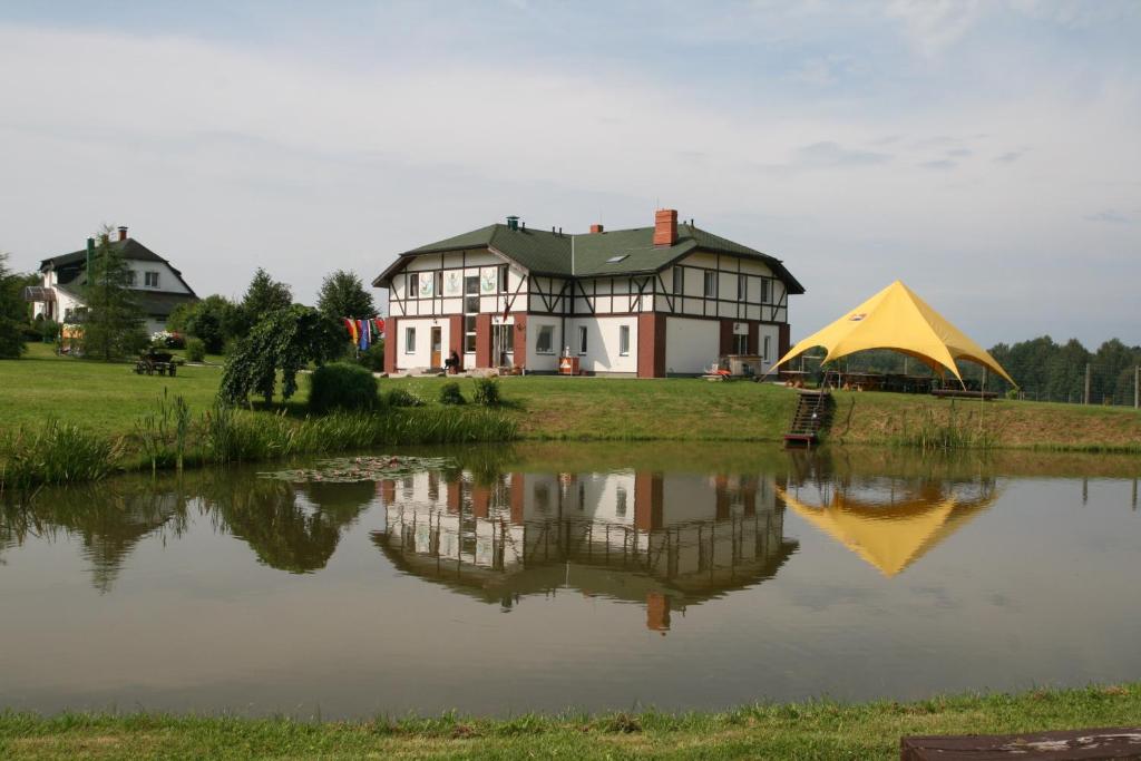 a house with a yellow tent next to a lake at More Guesthouse in More