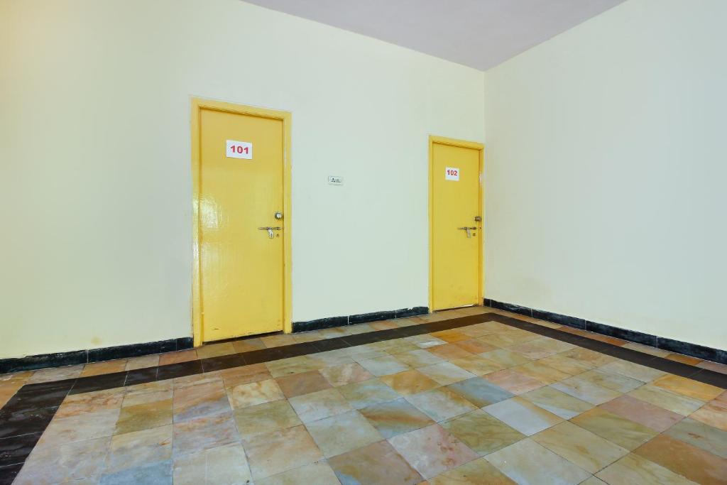 two yellow doors in a room with a tiled floor at Hotel O Sai Residency Near SR Nagar metro station in Hyderabad