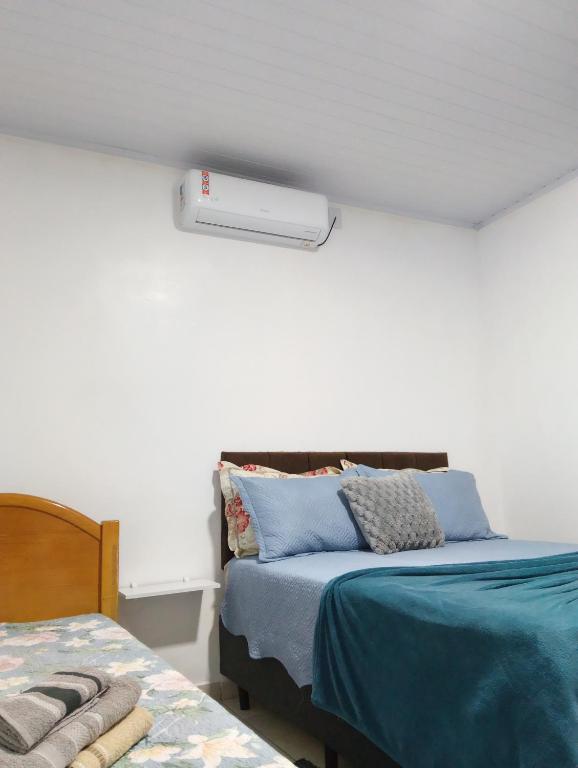 a bedroom with a bed and a heater on the wall at Cantinho da Ju in Osório