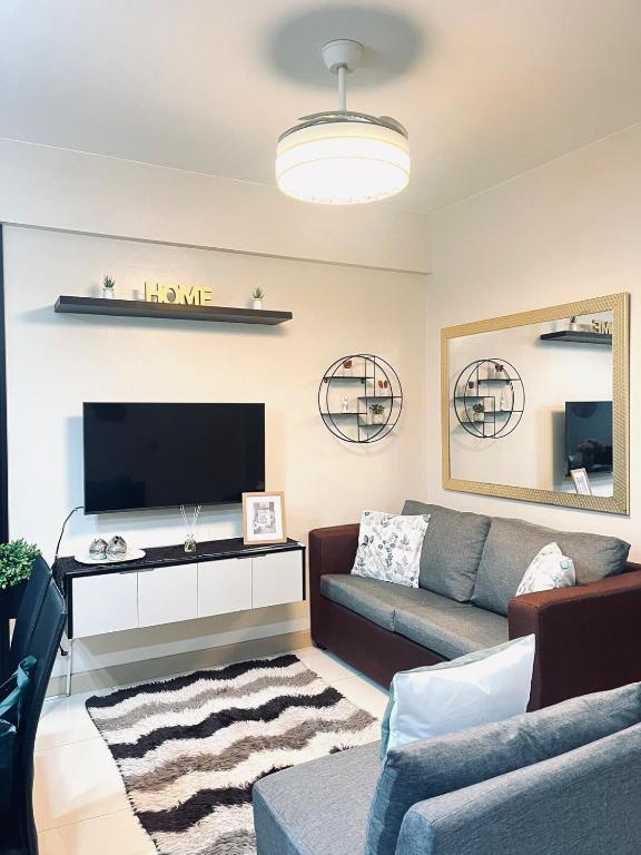 a living room with a couch and a tv at Camella Northpoint Spacious 3rd Floor Unit in Davao City