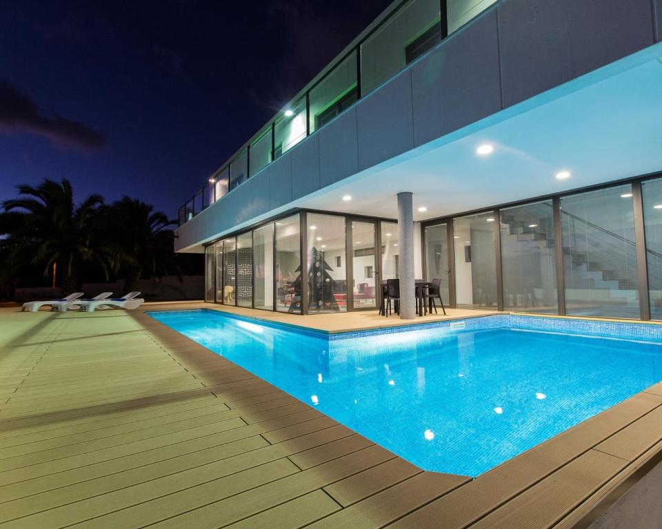 a swimming pool in front of a house at night at Atlantic Luxury Veranda in Calheta
