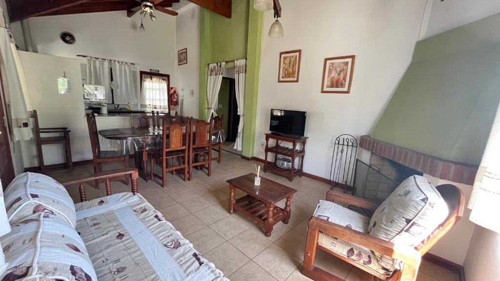 a living room with a couch and a dining room at Cabañas Aldea Blanca in Merlo