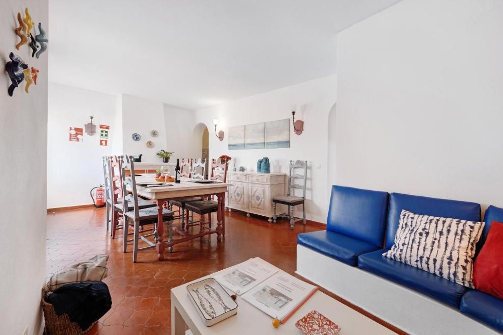 a living room with a blue couch and a table at Casa Branca in Luz