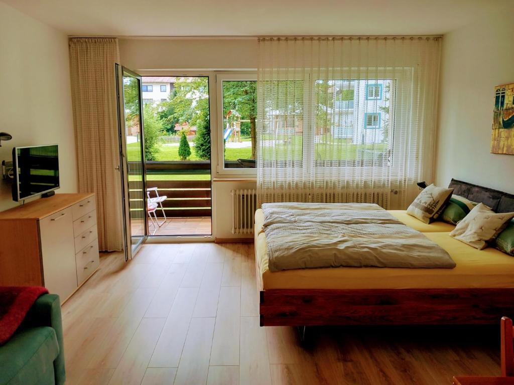a bedroom with a bed and a sliding glass door at Wohnung Isarnähe in Wackersberg