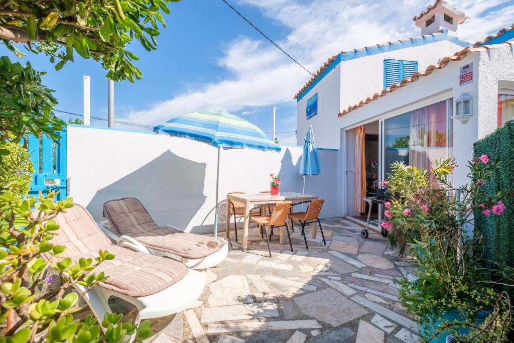un patio avec une table, des chaises et un parasol dans l'établissement Vistamar 1, à Vinaròs