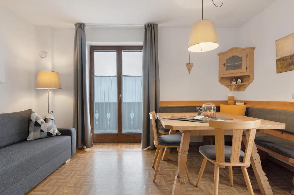 a living room with a table and a couch at Stieberhof Appartement in Feldthurns