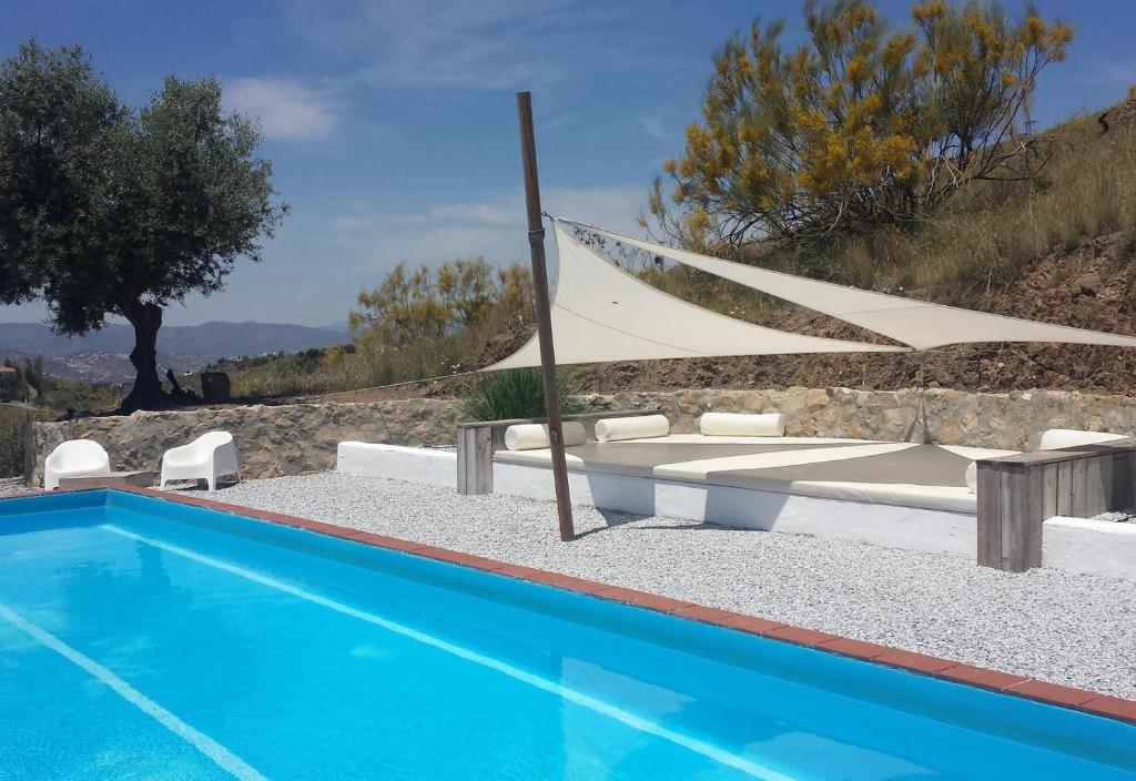 a pool with two lounge chairs and a swimming pool at Casa Canillas Bo in Canillas de Aceituno