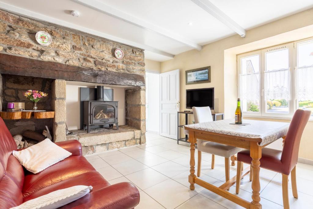una sala de estar con una mesa y una chimenea en Gite Cheminée, Kerantum, Au Calme, en Mahalon