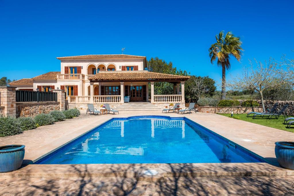 una casa con piscina delante de una casa en Villa Copinya Blanca, en Santanyí